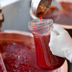Confiture versée à la louche depuis un chaudron de cuivre pendant l'atelier