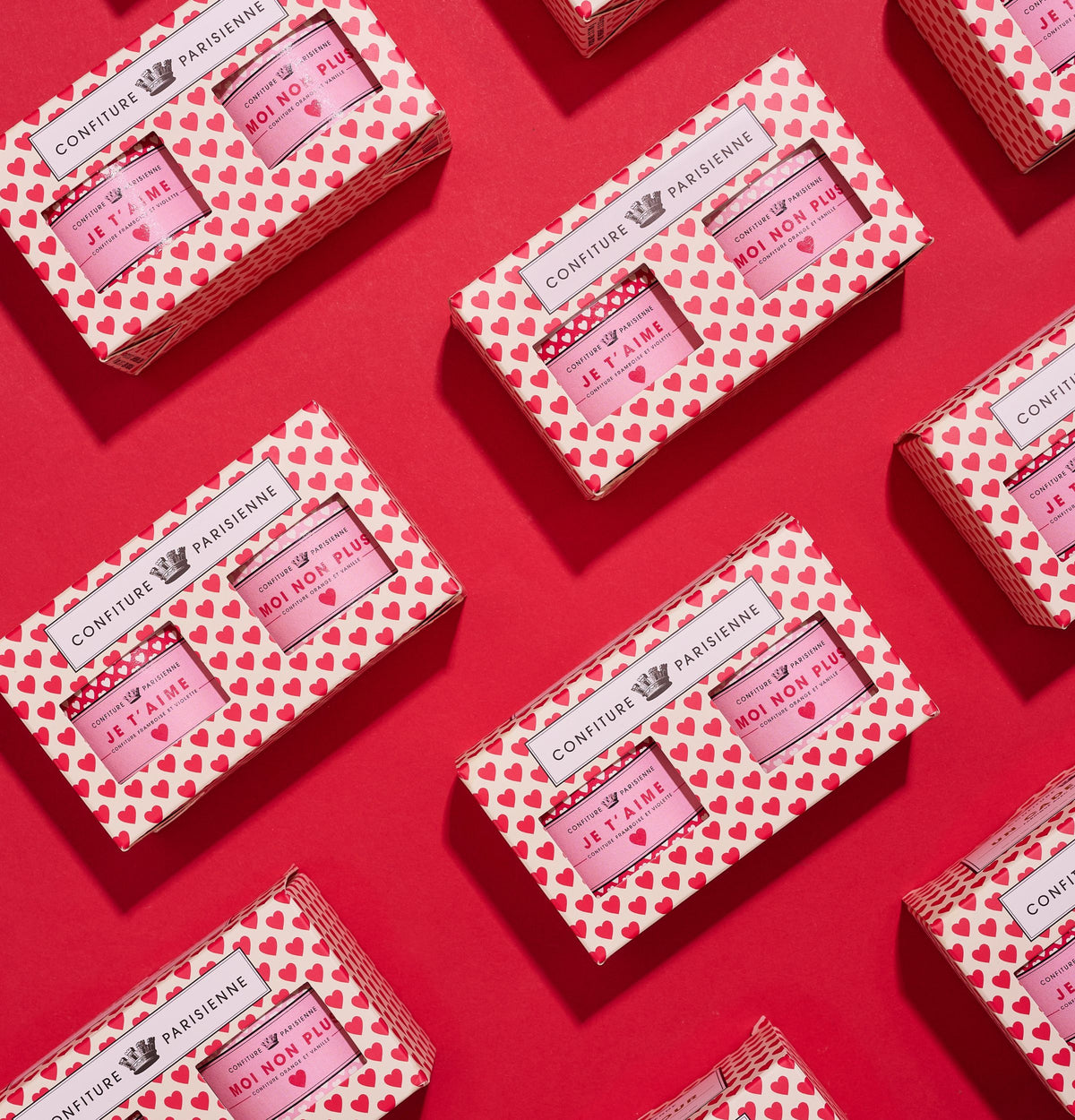 Coffrets « Je t'aime, moi non plus » 2 x 100 g à motif de cœurs rouges alignés en diagonale sur fond rouge