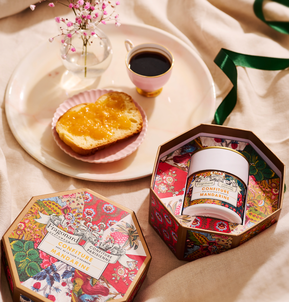 Coffret Mandarine Fleur d'Oranger x Fragonard ouvert sur une table de petit déjeuner avec tartine et café