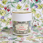 Image générée : pot Puits d'Amour x À Paris chez Antoinette Poisson posé sur un tissu à motifs de fraises et de feuillages