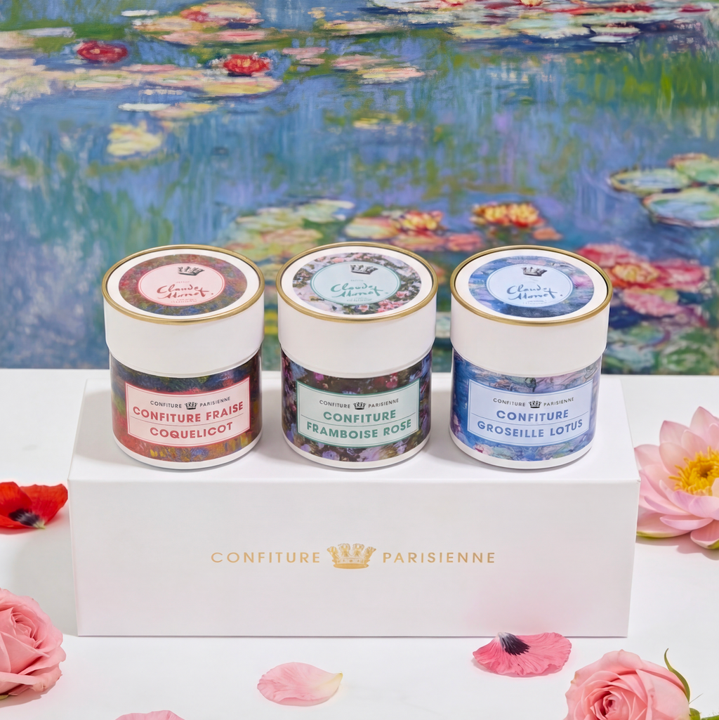Coffret de trois pots de la sélection Claude Monet devant un tableau de nymphéas, entouré de fleurs